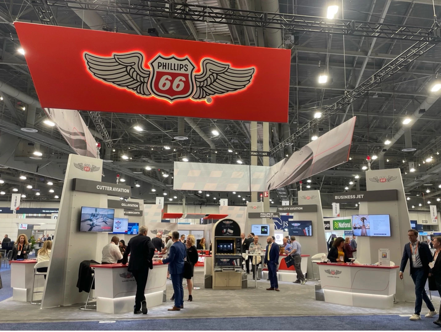 NBAA-BACE attendees interacting with Phillips 66 Aviation staff at a conference booth. 